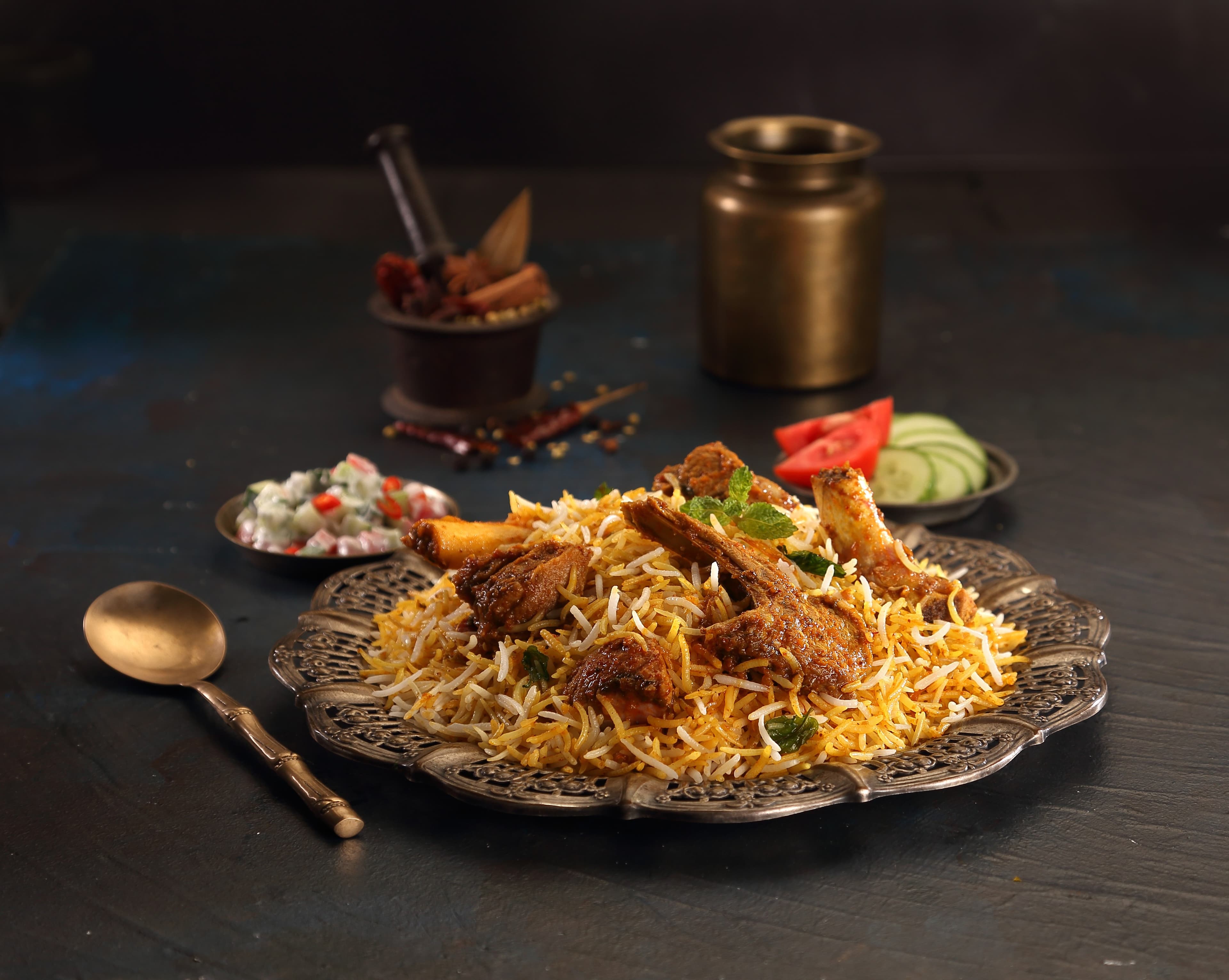 Mutton Biryani โ slow-cooked tender mutton layered with aged basmati and ground house masala, crowned with birista
